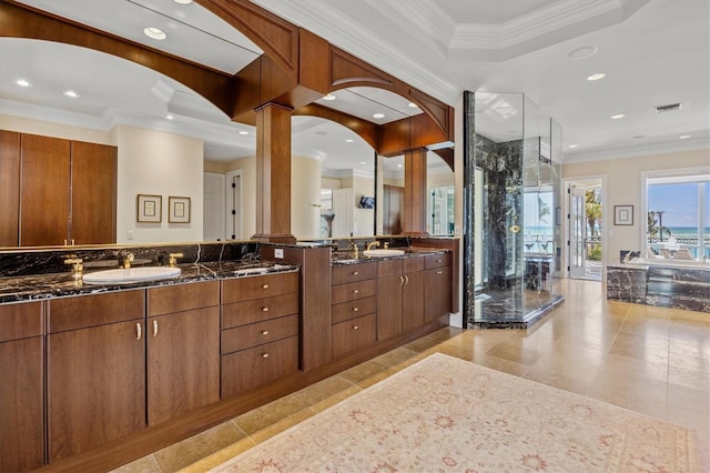 bathroom with ornate columns, crown molding, and vanity