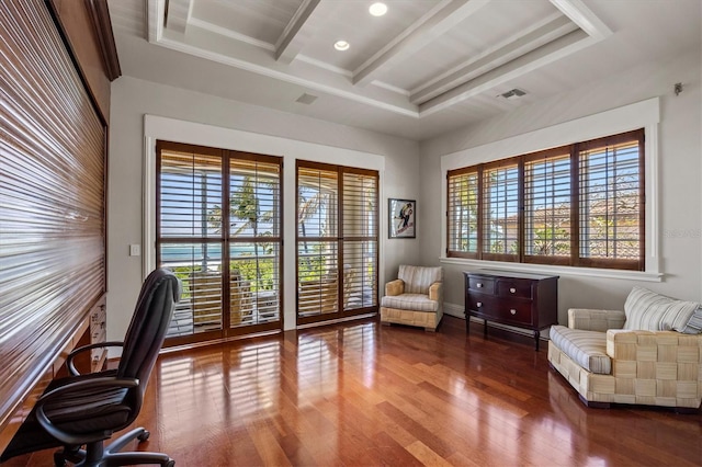 home office featuring beamed ceiling, ornamental molding, a raised ceiling, and hardwood / wood-style floors