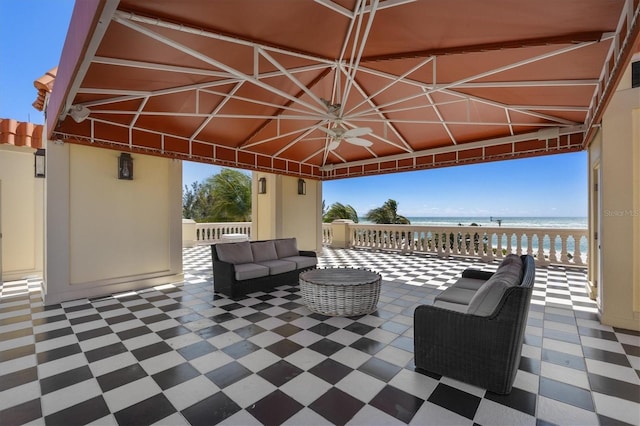 view of patio / terrace featuring an outdoor living space, a water view, and a beach view