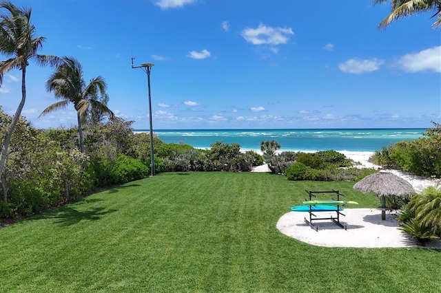 view of home's community with a patio, a water view, and a lawn