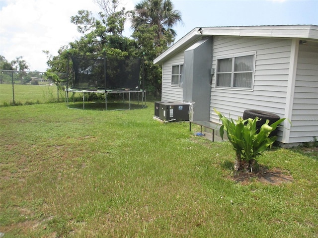 view of yard with a trampoline and cooling unit