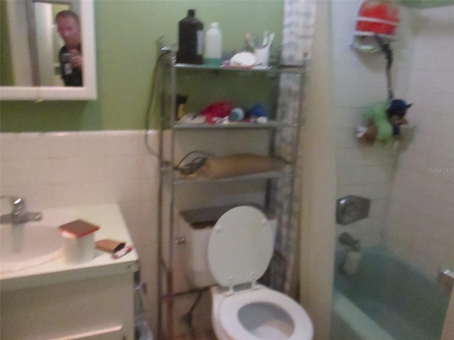 full bathroom with tiled shower / bath combo, vanity, tile walls, and toilet