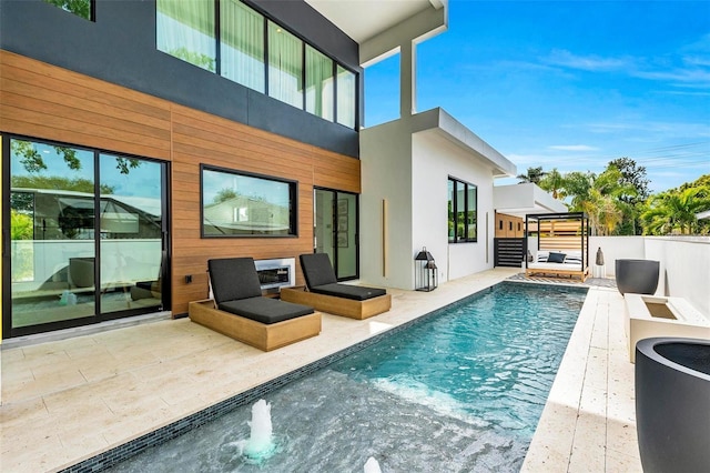 rear view of house with pool water feature, a fenced in pool, and a patio area