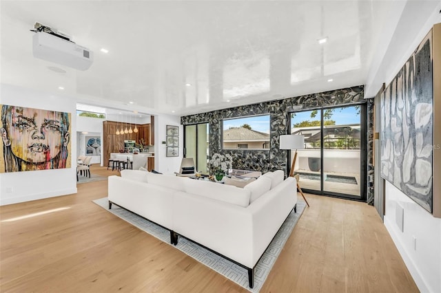 living area with recessed lighting, light wood-style flooring, and baseboards