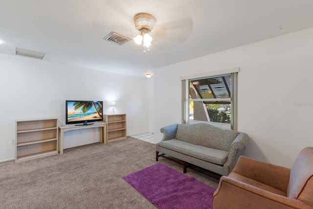 living area with carpet, attic access, visible vents, and a ceiling fan