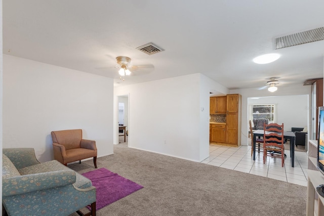 sitting room with light carpet, ceiling fan, and visible vents