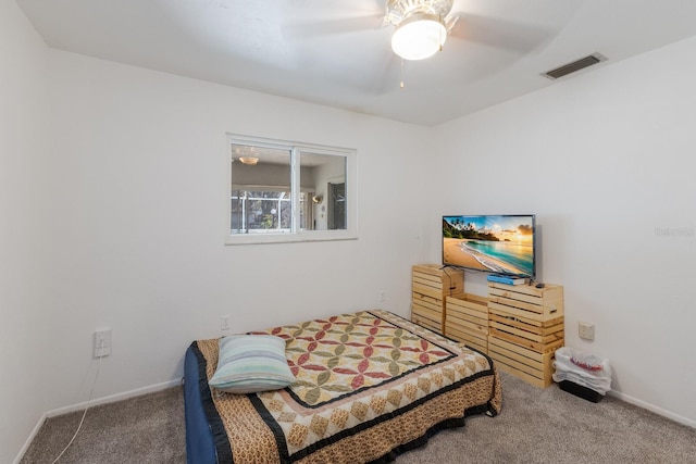 carpeted bedroom featuring a ceiling fan, visible vents, and baseboards