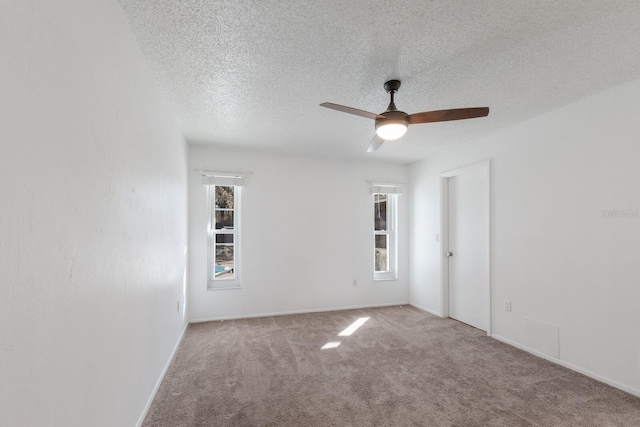 carpeted empty room with ceiling fan and a textured ceiling