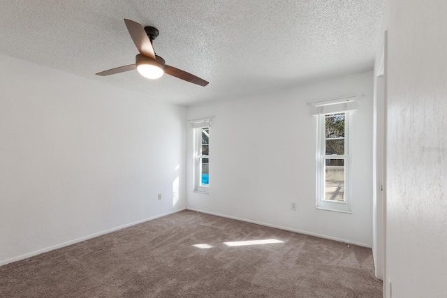 spare room with ceiling fan, light colored carpet, and a textured ceiling