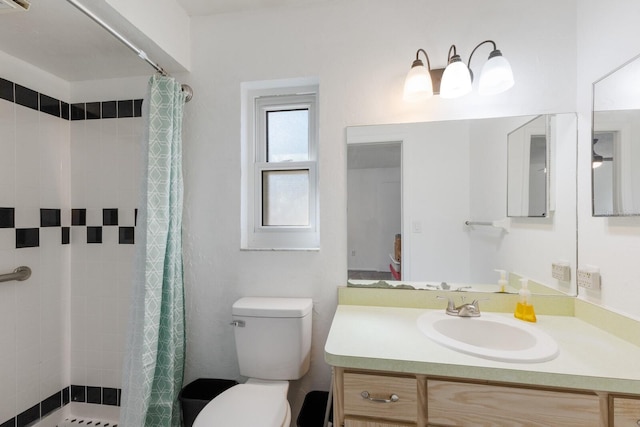 full bathroom featuring vanity, a tile shower, and toilet