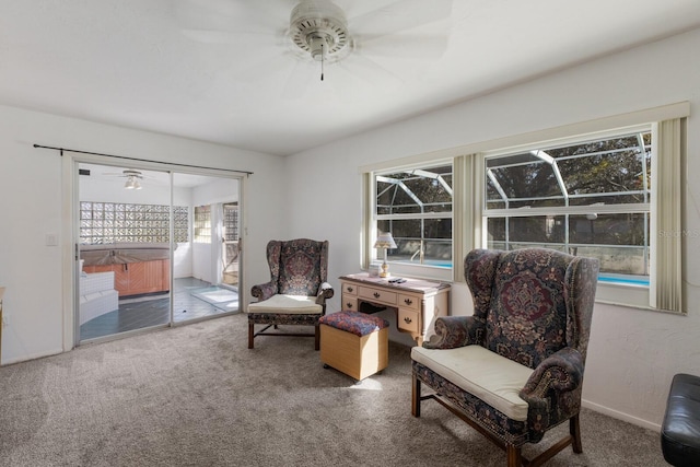 living area with carpet, a sunroom, and ceiling fan