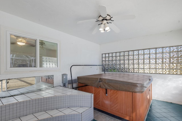 interior space with a ceiling fan, dark tile patterned flooring, and a hot tub