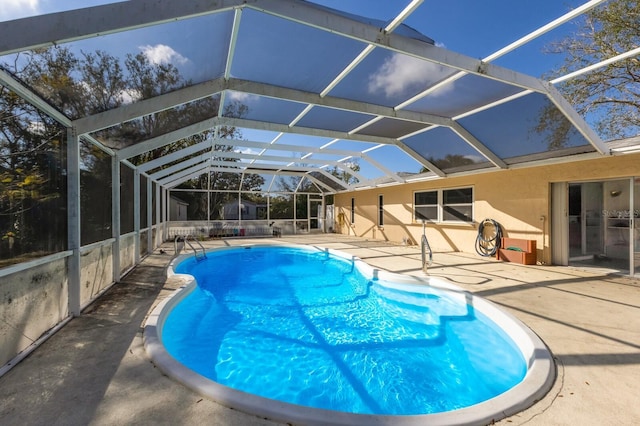 view of pool with a patio and glass enclosure