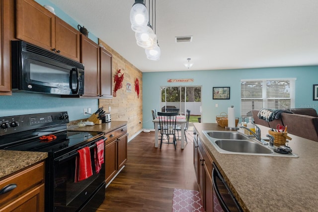 kitchen featuring dark wood-type flooring, sink, hanging light fixtures, a wealth of natural light, and black appliances