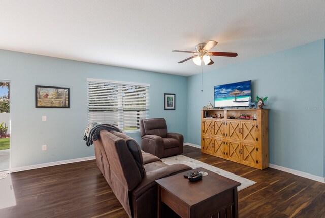 living room with dark hardwood / wood-style flooring and ceiling fan