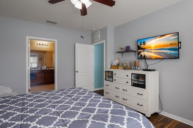 bedroom featuring ceiling fan, ensuite bath, and dark hardwood / wood-style floors