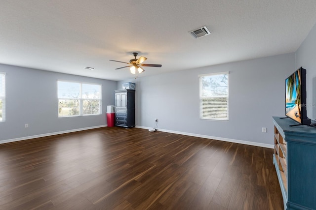 unfurnished living room featuring a textured ceiling, dark wood-type flooring, and ceiling fan