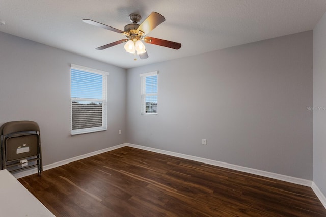 unfurnished office with dark hardwood / wood-style flooring and ceiling fan