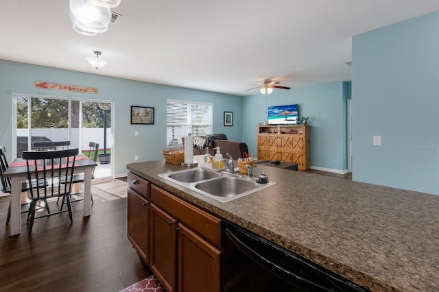 kitchen with a sink, black dishwasher, a ceiling fan, dark wood-style flooring, and healthy amount of natural light