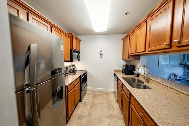 kitchen with light stone counters, sink, and appliances with stainless steel finishes