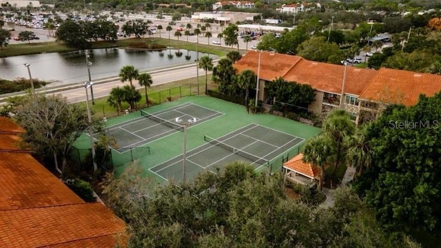 view of tennis court with a water view