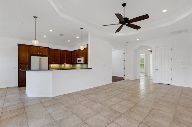 kitchen with pendant lighting, light tile patterned floors, ceiling fan, high end refrigerator, and a raised ceiling