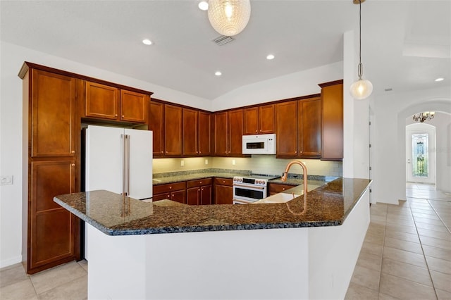 kitchen with light tile patterned flooring, sink, hanging light fixtures, kitchen peninsula, and white appliances