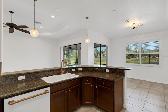 kitchen with sink, white dishwasher, a wealth of natural light, pendant lighting, and dark stone counters