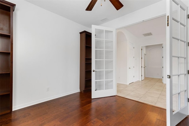 unfurnished room with hardwood / wood-style floors, french doors, and ceiling fan