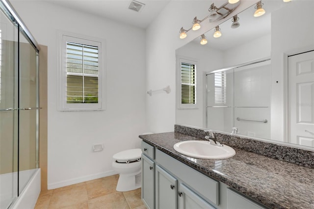 full bathroom featuring vanity, tile patterned floors, combined bath / shower with glass door, and toilet