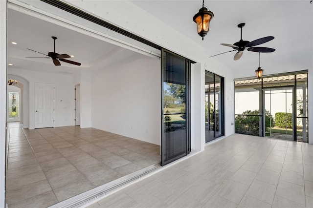 interior space with a raised ceiling and ceiling fan