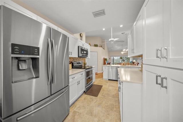 kitchen with white cabinetry, decorative backsplash, ceiling fan, kitchen peninsula, and stainless steel appliances