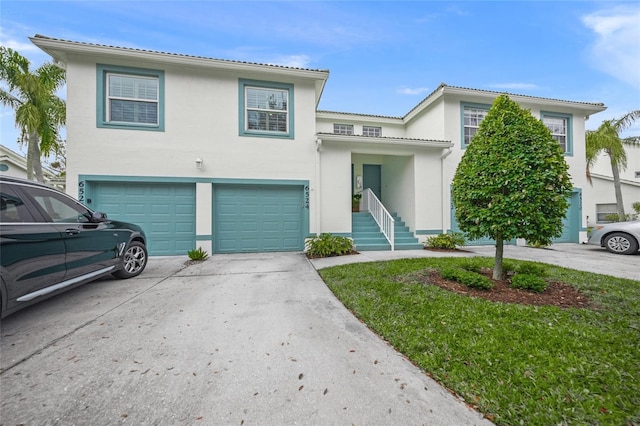 view of front of property featuring driveway, an attached garage, and stucco siding