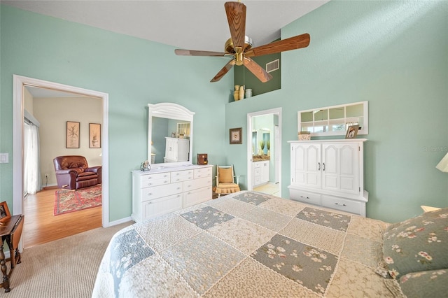 bedroom featuring light colored carpet, visible vents, a high ceiling, and baseboards