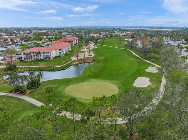 drone / aerial view with a water view and golf course view