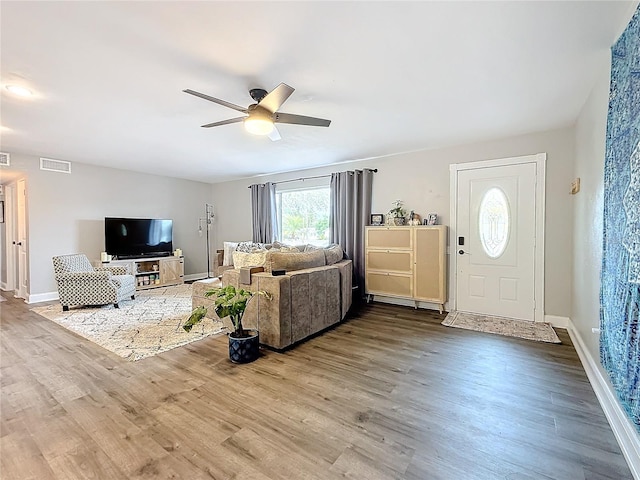 living room featuring hardwood / wood-style floors and ceiling fan