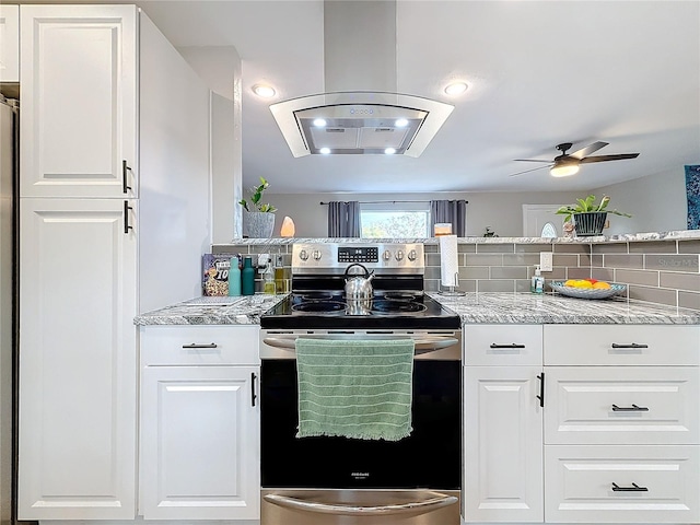 kitchen featuring ceiling fan, white cabinetry, light stone counters, island exhaust hood, and stainless steel electric stove