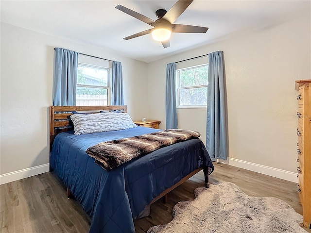 bedroom with hardwood / wood-style flooring, ceiling fan, and multiple windows