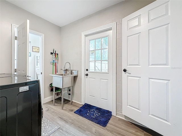 doorway to outside featuring sink and light hardwood / wood-style floors