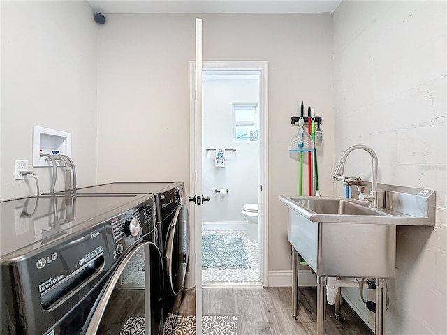 clothes washing area with hardwood / wood-style flooring and washer and clothes dryer