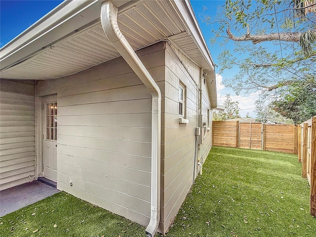 view of side of home with a yard