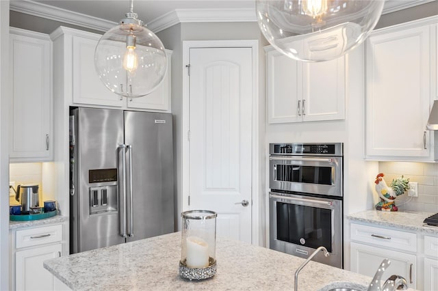 kitchen featuring stainless steel appliances, light stone countertops, white cabinets, and decorative backsplash