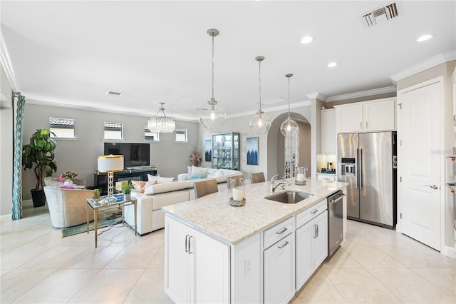 kitchen featuring stainless steel appliances, sink, a center island with sink, and white cabinets