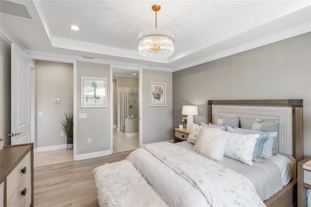 bedroom with an inviting chandelier, ornamental molding, a raised ceiling, and light hardwood / wood-style flooring