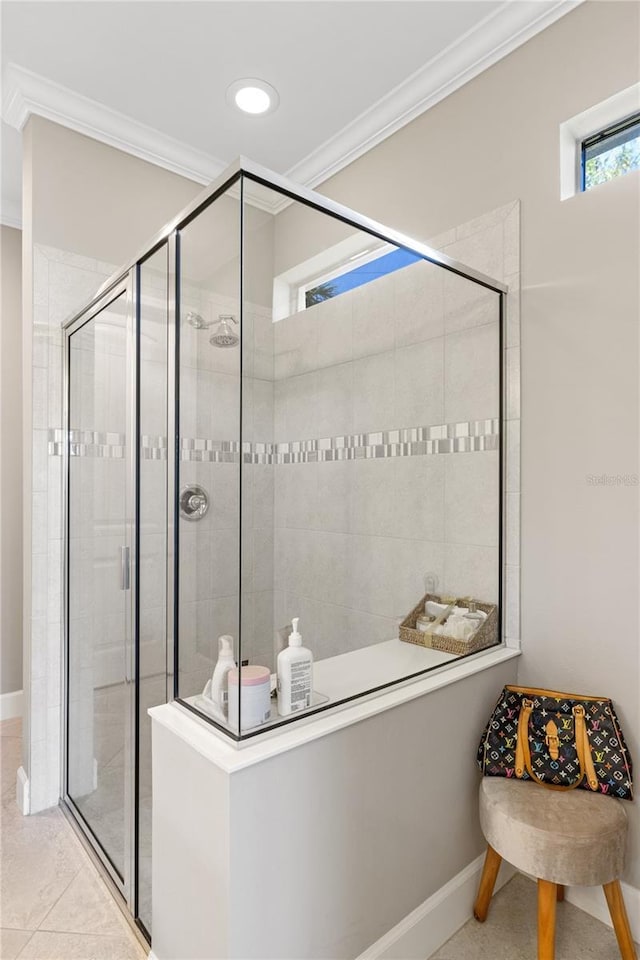 bathroom with crown molding, tile patterned flooring, and a tile shower