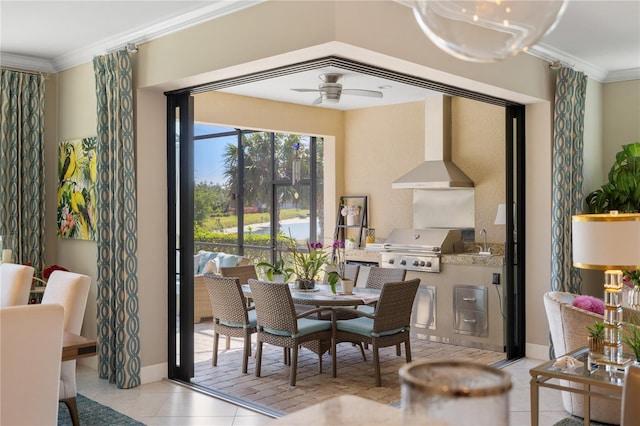 dining area featuring ceiling fan, ornamental molding, sink, and light tile patterned floors