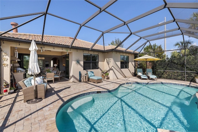 view of swimming pool featuring a lanai and a patio area