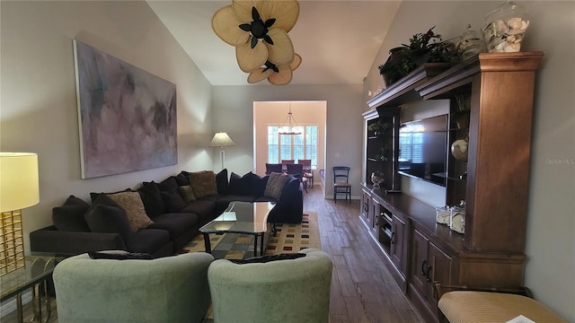 living room featuring dark wood-type flooring, ceiling fan, and vaulted ceiling