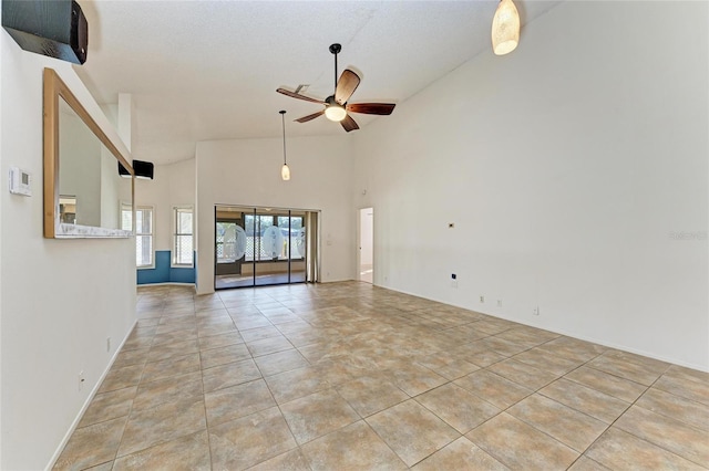 unfurnished living room with light tile patterned floors, high vaulted ceiling, and ceiling fan