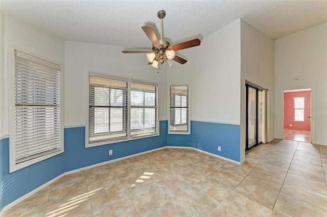 tiled spare room featuring a textured ceiling and ceiling fan